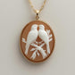 Gold necklace with a pendant featuring two birds on a branch against a beige background