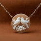 Necklace with a circular pendant featuring two birds on a floral branch