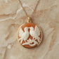 Gold necklace with a pendant featuring two birds on a beige marble background