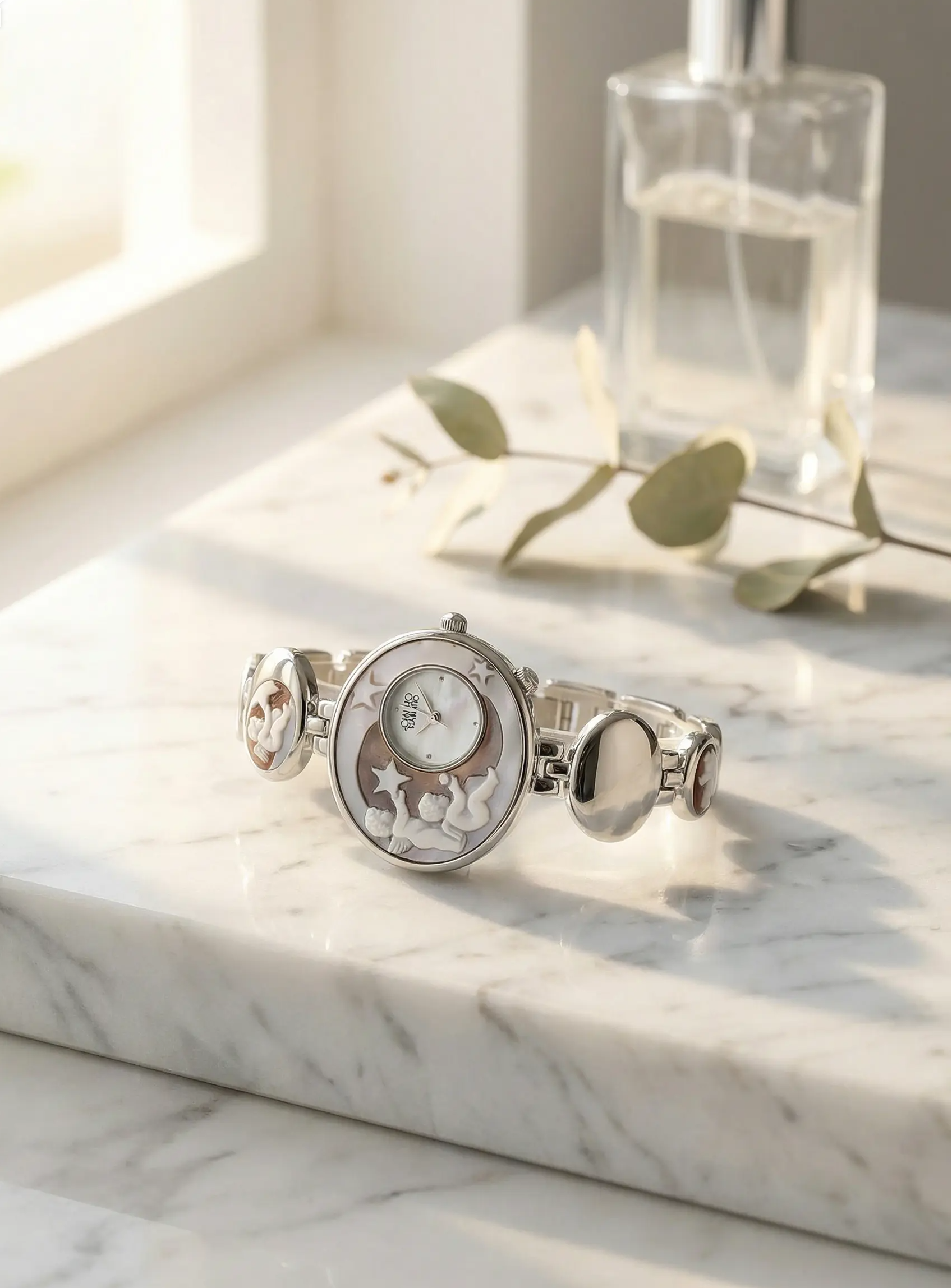 Silver watch with decorative face on a marble surface