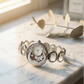 Silver bracelet with a detailed face on a marble surface