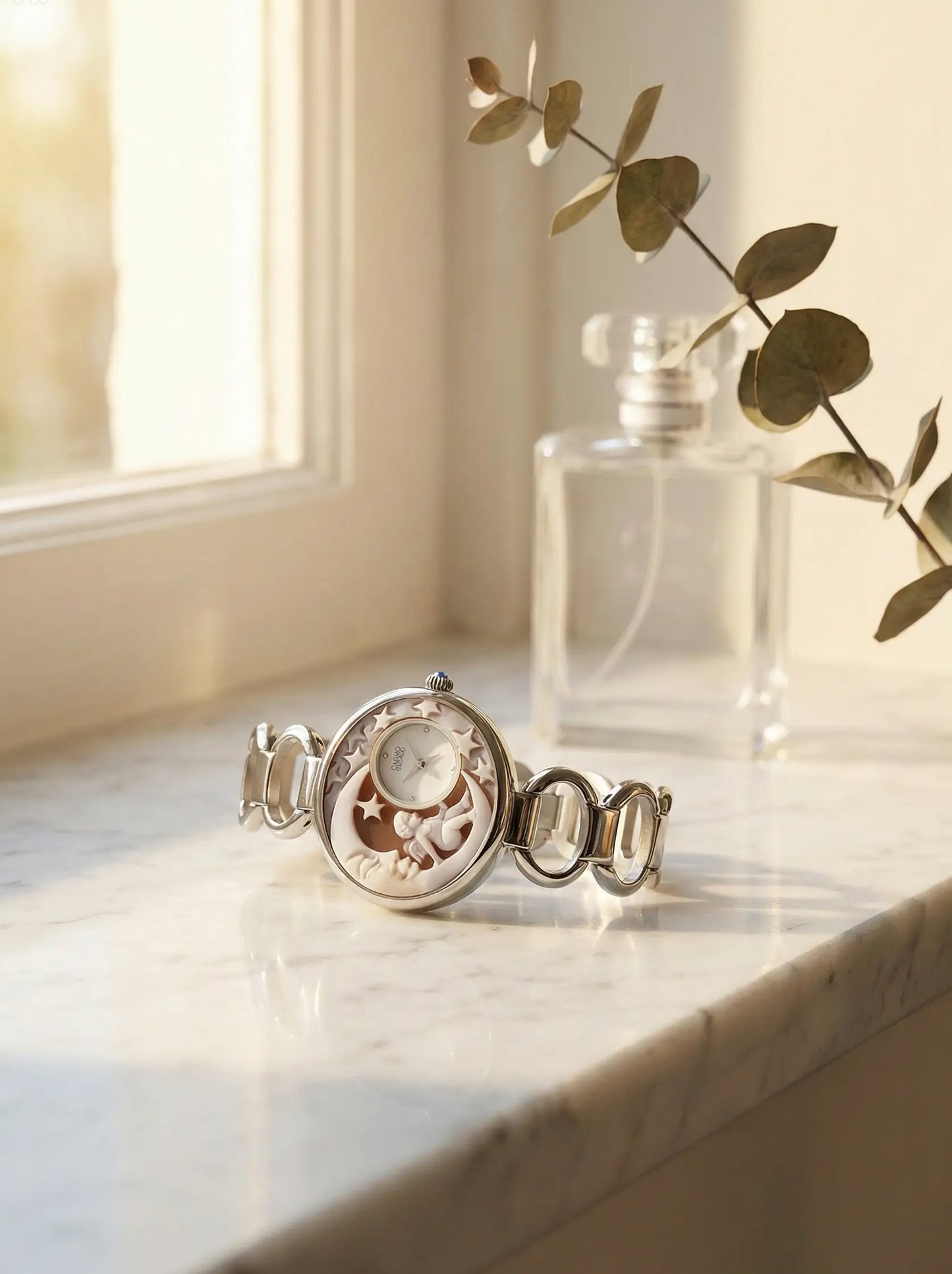 Silver bracelet with intricate design on a marble surface next to a clear glass bottle.