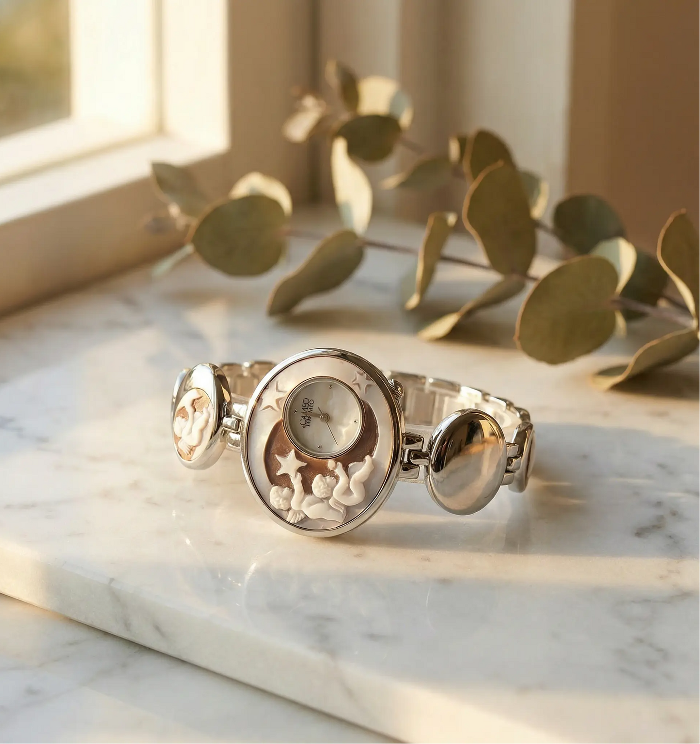 Silver bracelet watch on a marble surface with eucalyptus leaves elegant wrist watch old money
