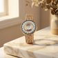 Gold cameo watch with floral design on a marble surface