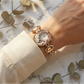 Rose gold watch on a wrist with a marble background and eucalyptus leaves